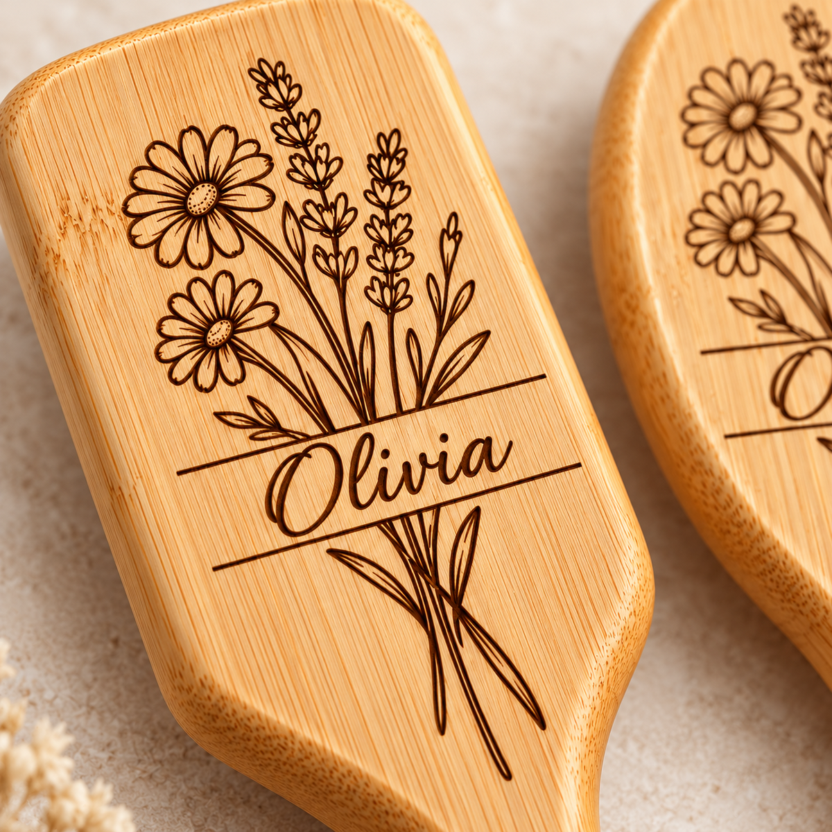 Close-up of floral engraving and custom name on bamboo hairbrush