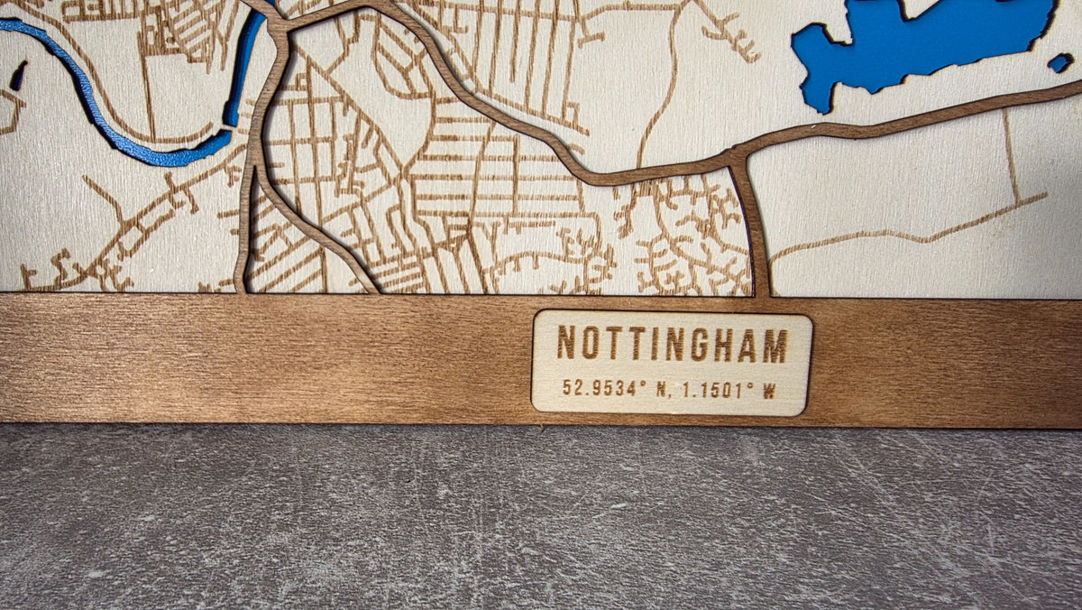 Close-up of city name and longitude latitude on lower wooden plaque